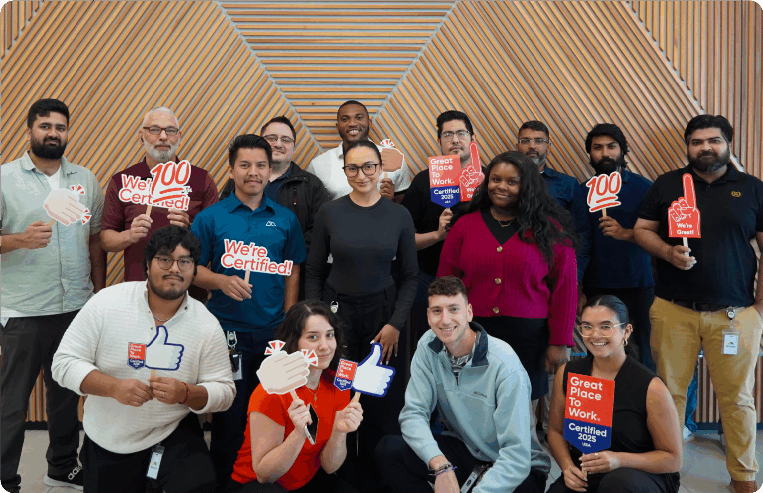 Modisoft team members pose with Great Place to Work Certified signs and props during a workplace recognition event.