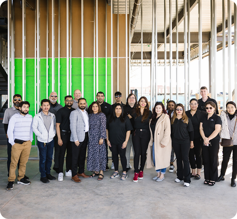 Modisoft team members gathered inside a commercial construction site with building materials and structural support.