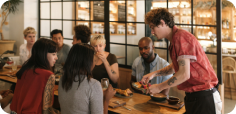 Group of customers gathered around a table sharing food and beverages in a casual dining setting.